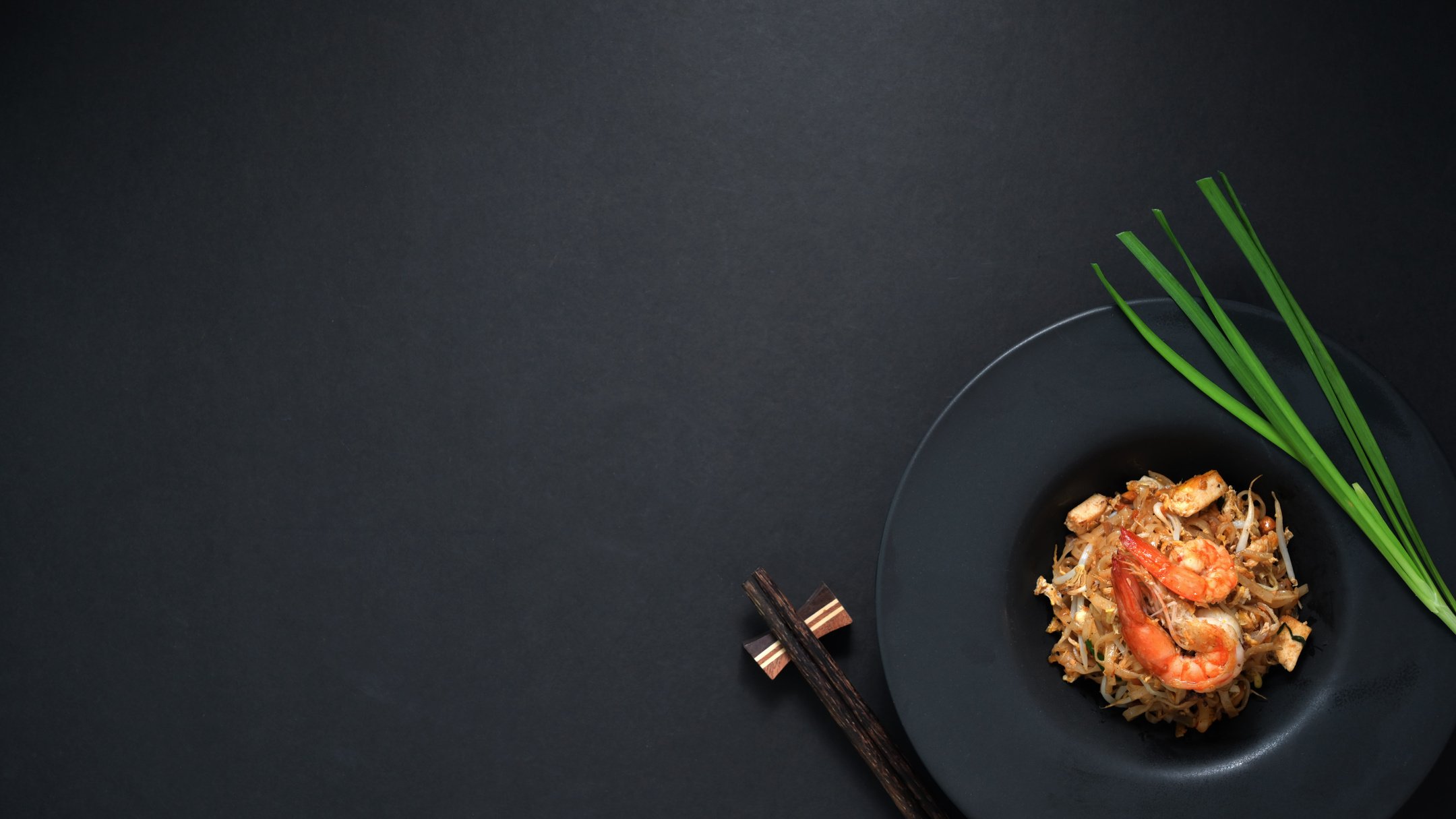 Top View of Pad Thai with Chopsticks on Black Background